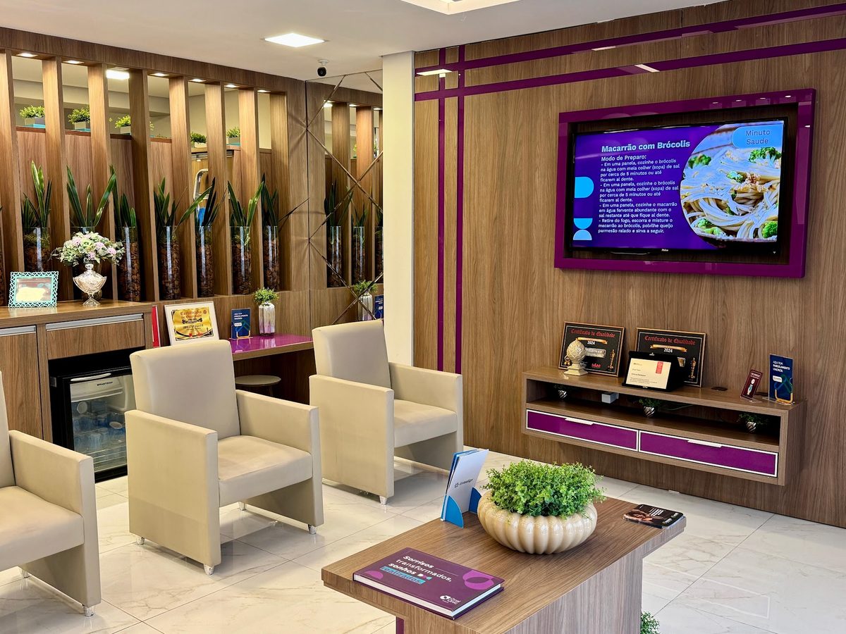 Sala de espera da Oral Unic Indaial com poltronas e televisão