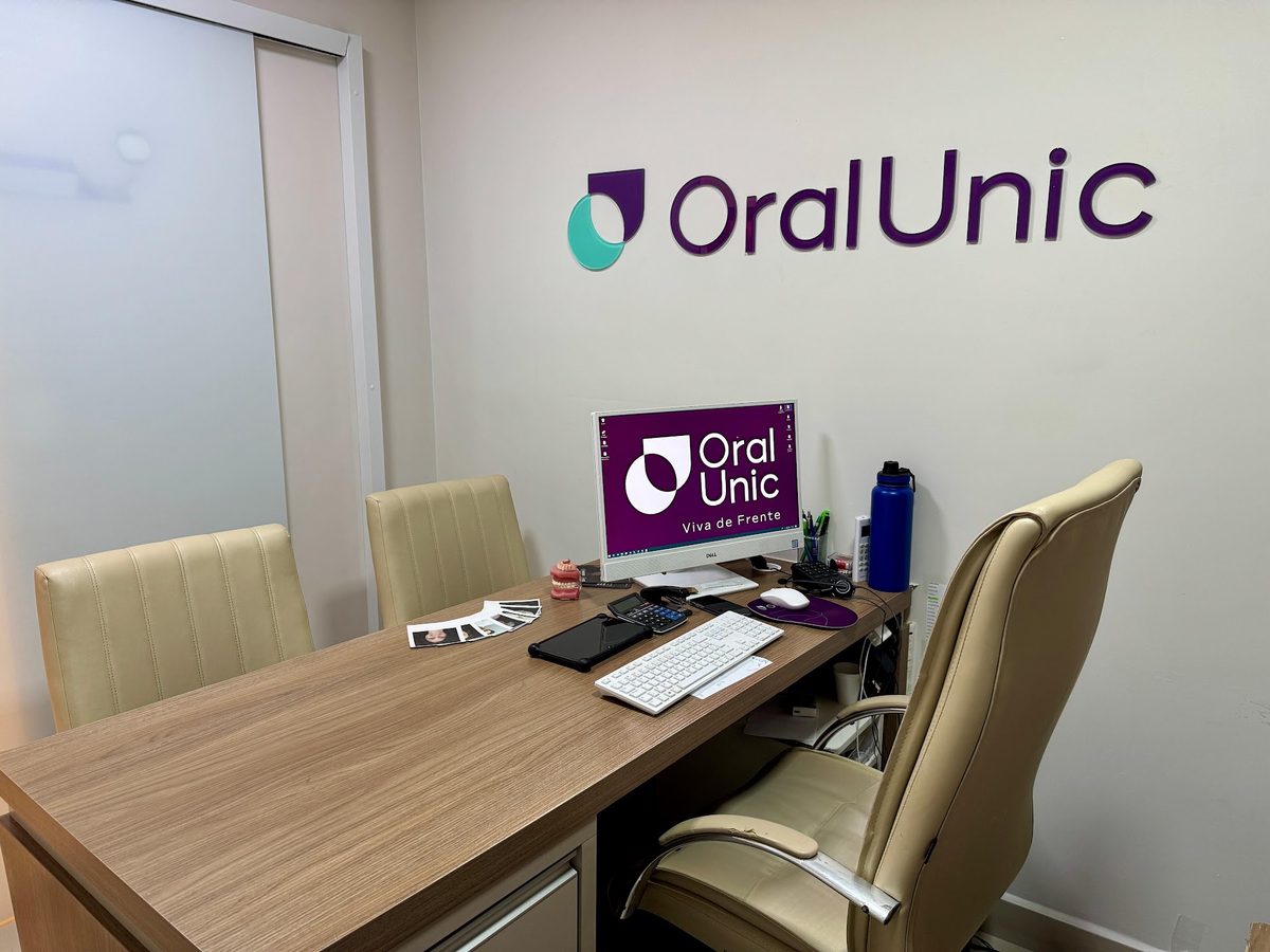 Sala de atendimento da Oral Unic Indaial com mesa de consulta